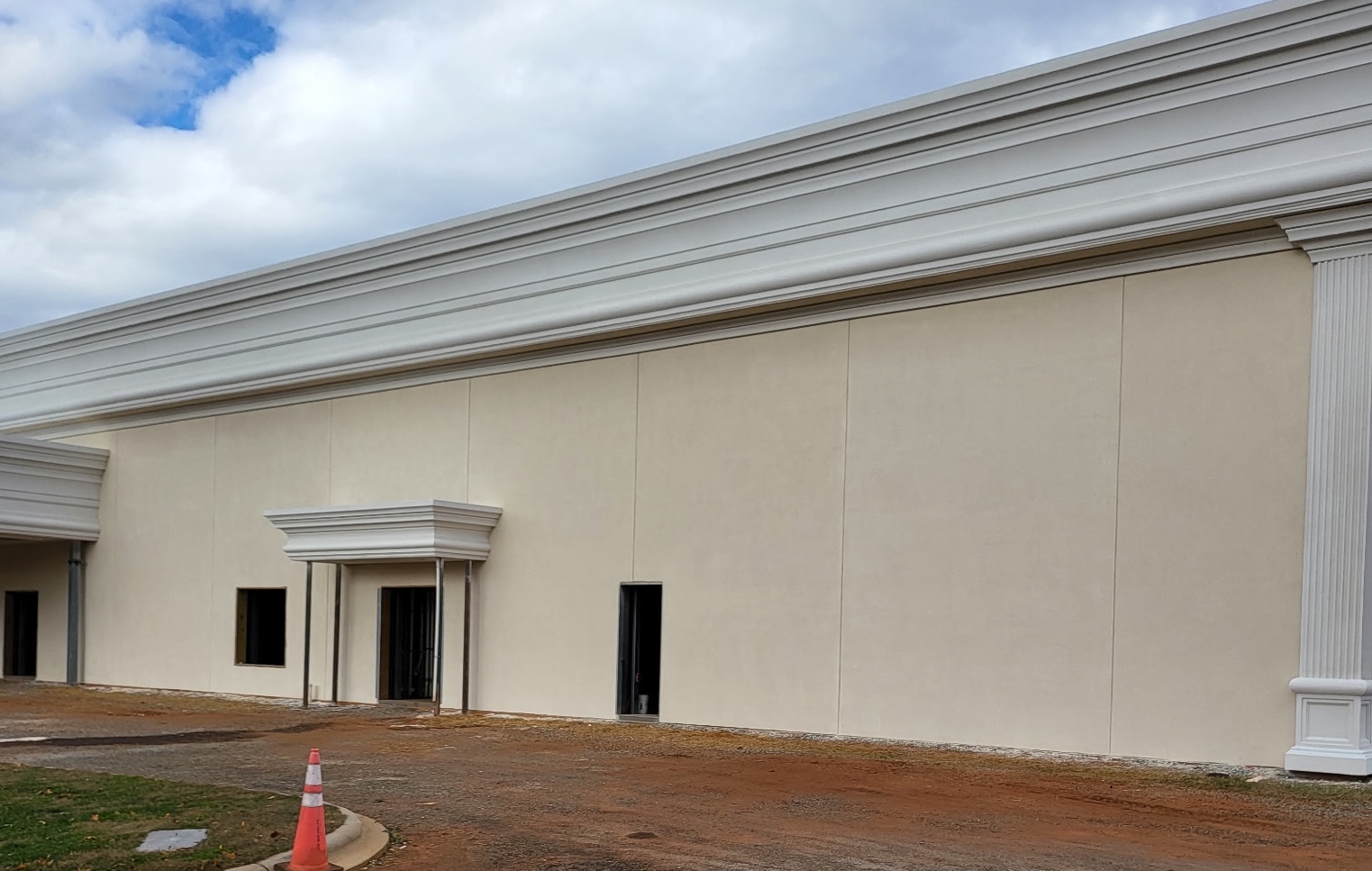 Commercial stucco exterior wall with detailed architectural cornice and columns