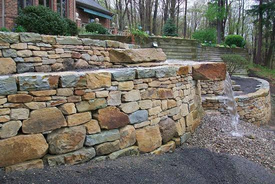 Terraced natural stone retaining walls on a landscaped residential slope