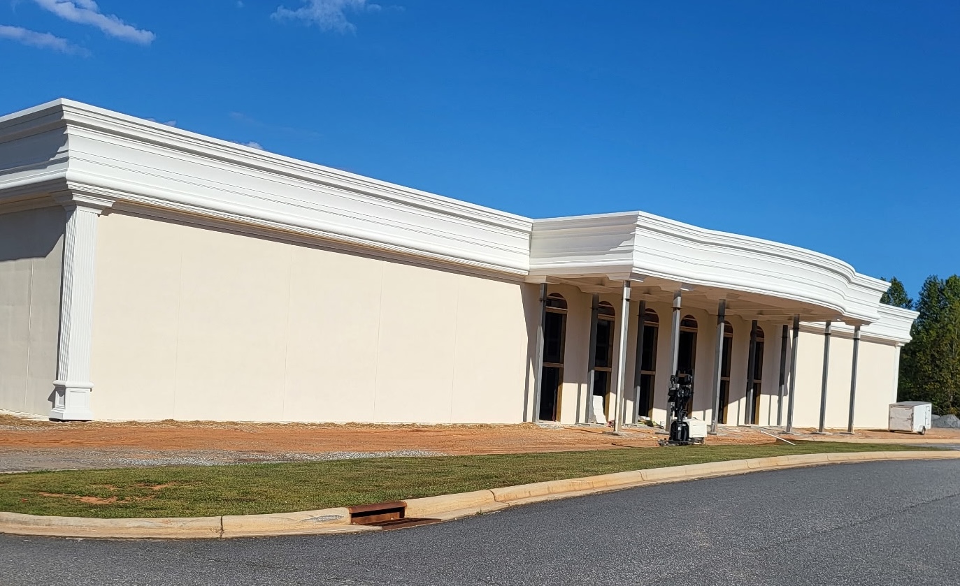 Large commercial building with finished stucco exterior and architectural cornice