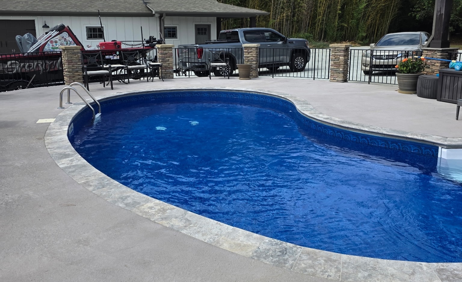 Finished residential swimming pool with stone coping and surrounding deck