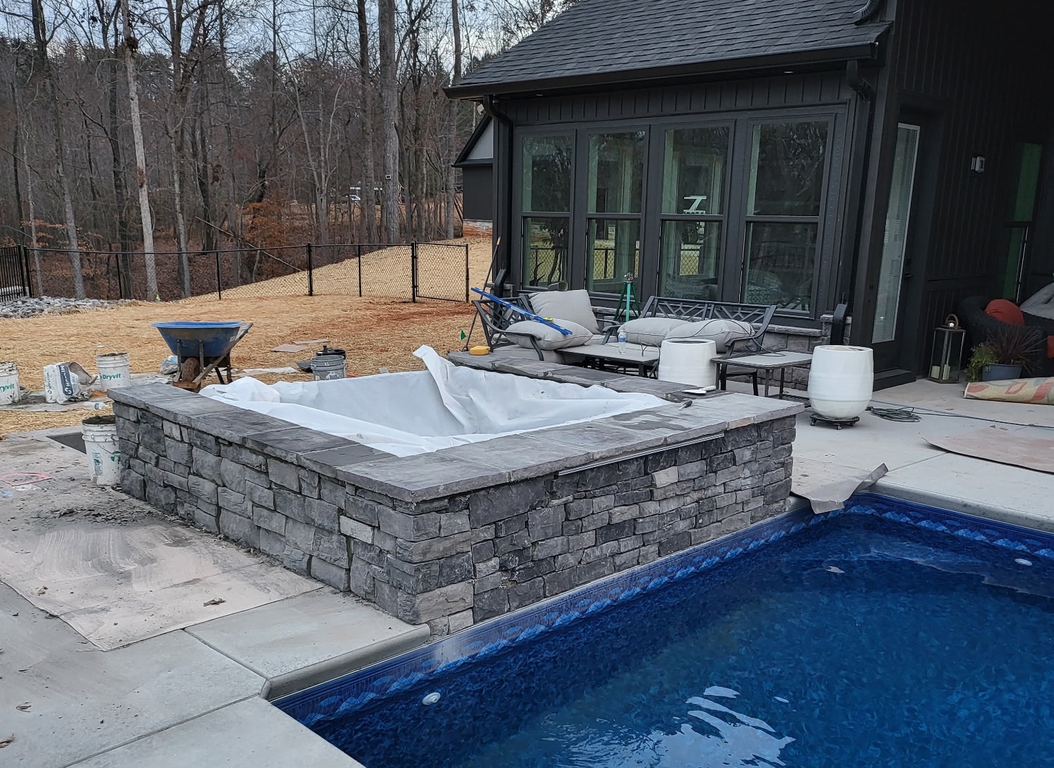 Raised stone pool feature beside a residential swimming pool
