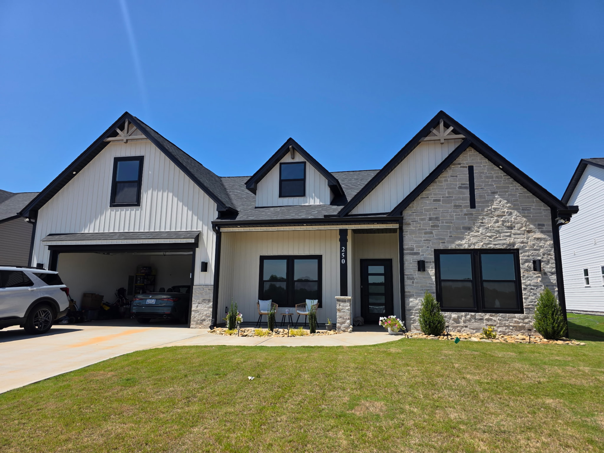 White farmhouse with gray stone gable and stone porch column