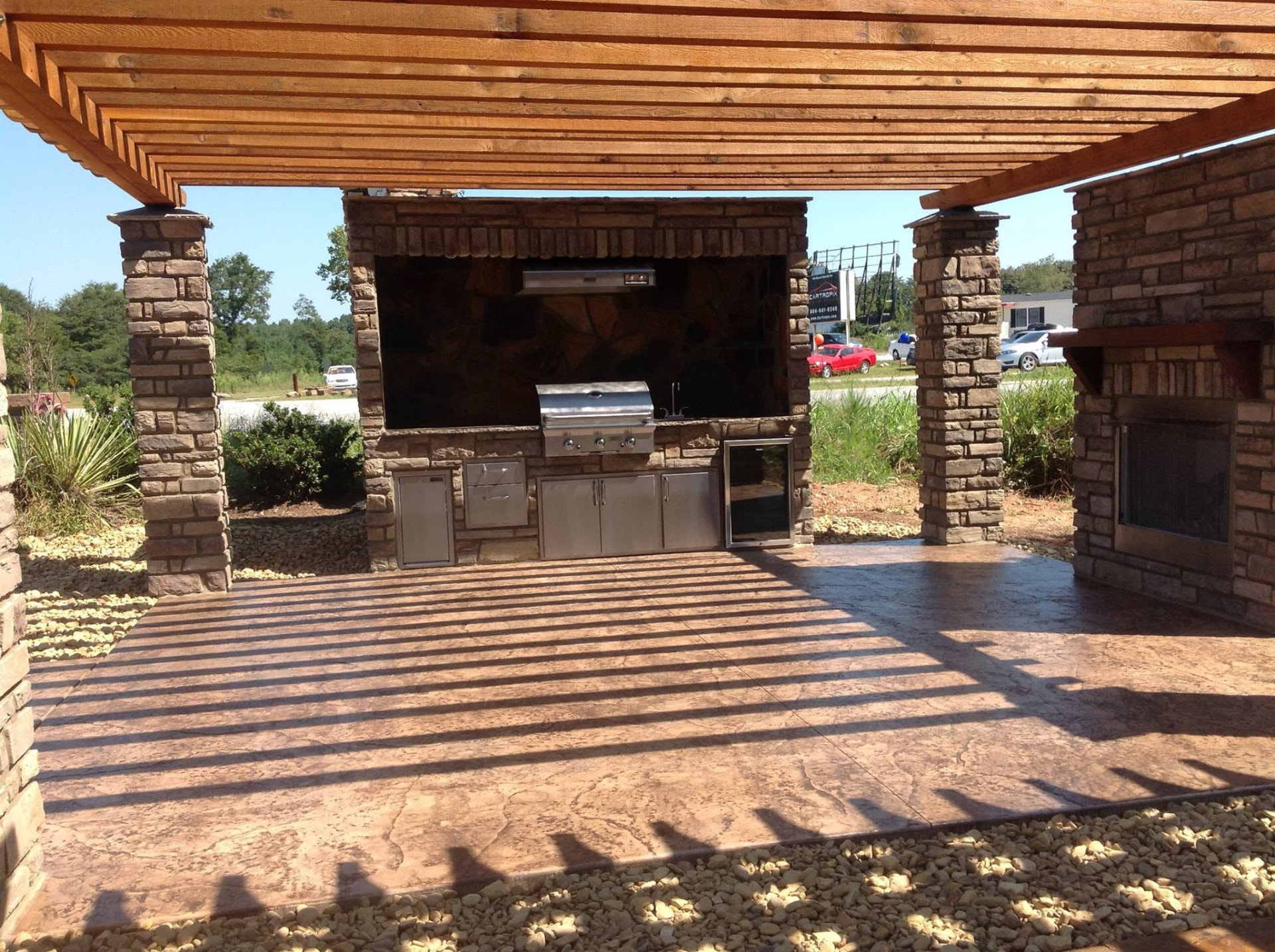 Wide view of a masonry outdoor kitchen with stainless steel appliances