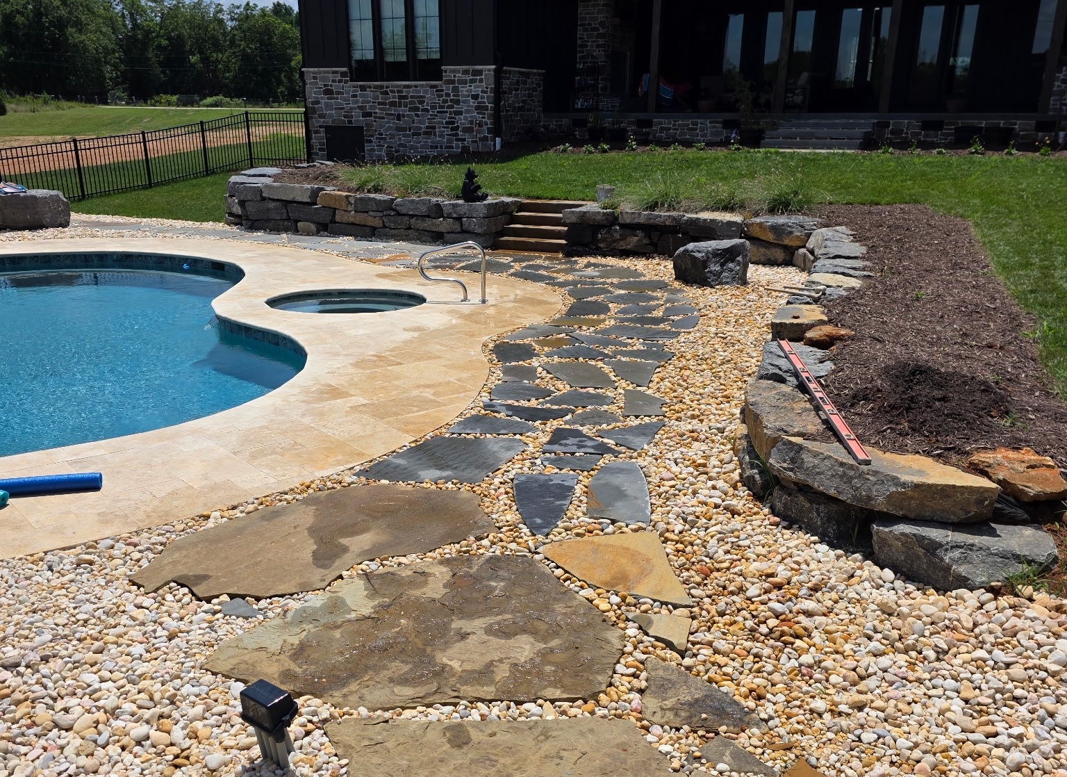 Decorative landscape rock and flagstone walkway surrounding a residential pool